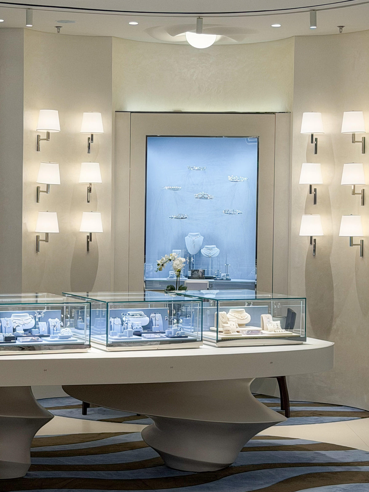 Curved white jewelry showcase blue feature wall