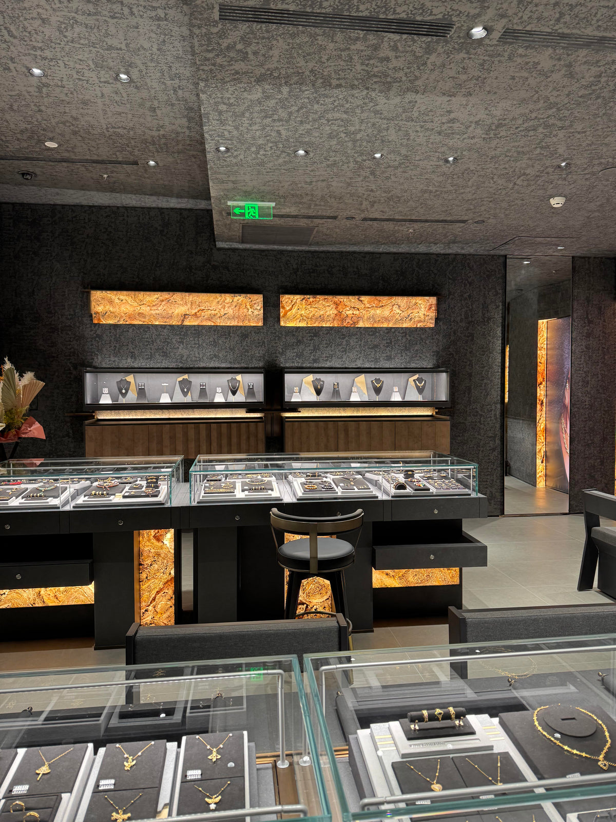 Dark textured wall jewelry store gold accents